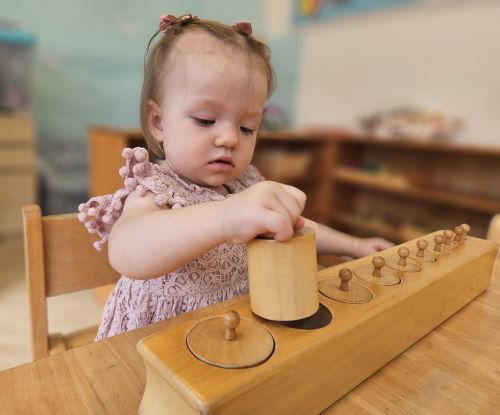 Toddler developing fine motor skills through hands-on Montessori sensory activities